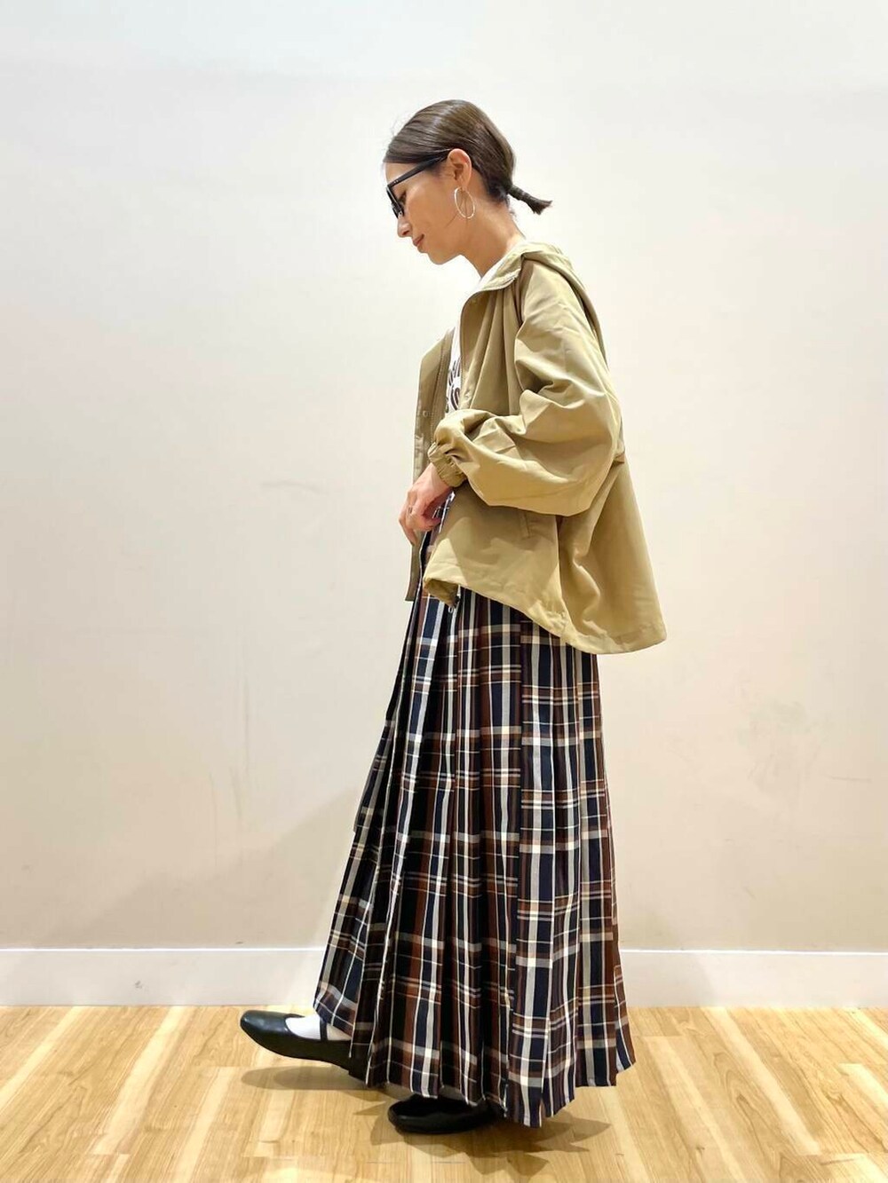 ブラック系のパンプス、ブラック系のトートバッグ、ブルー系のスカートを着用したレディースの秋コーディネートの2枚目の写真