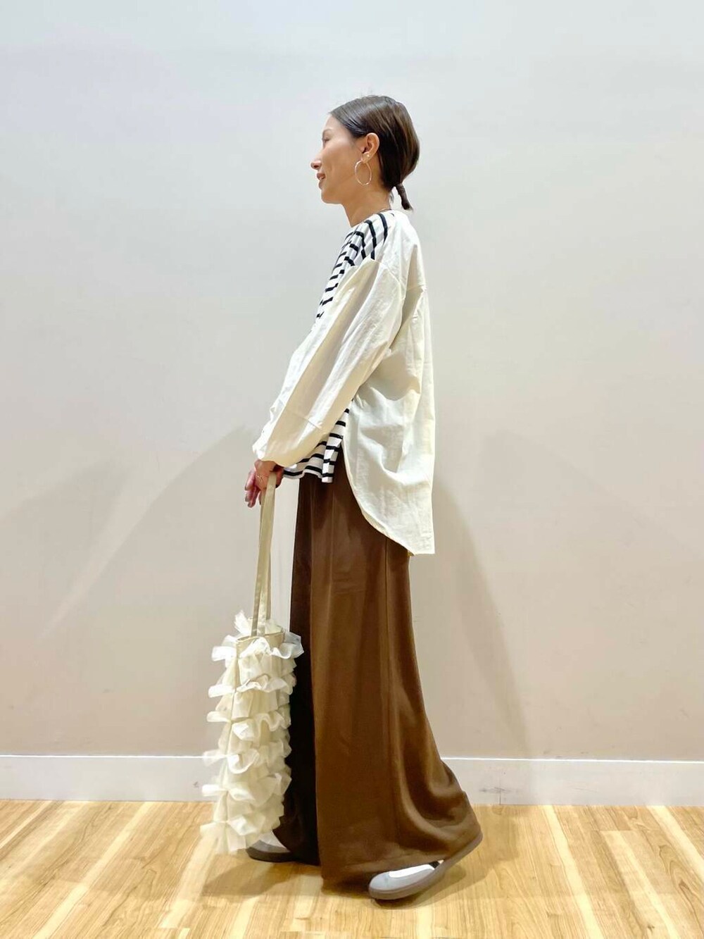 ホワイト系のトートバッグ、ホワイト系のTシャツ/カットソー、ブラウン系のその他パンツを着用したレディースの秋コーディネートの4枚目の写真