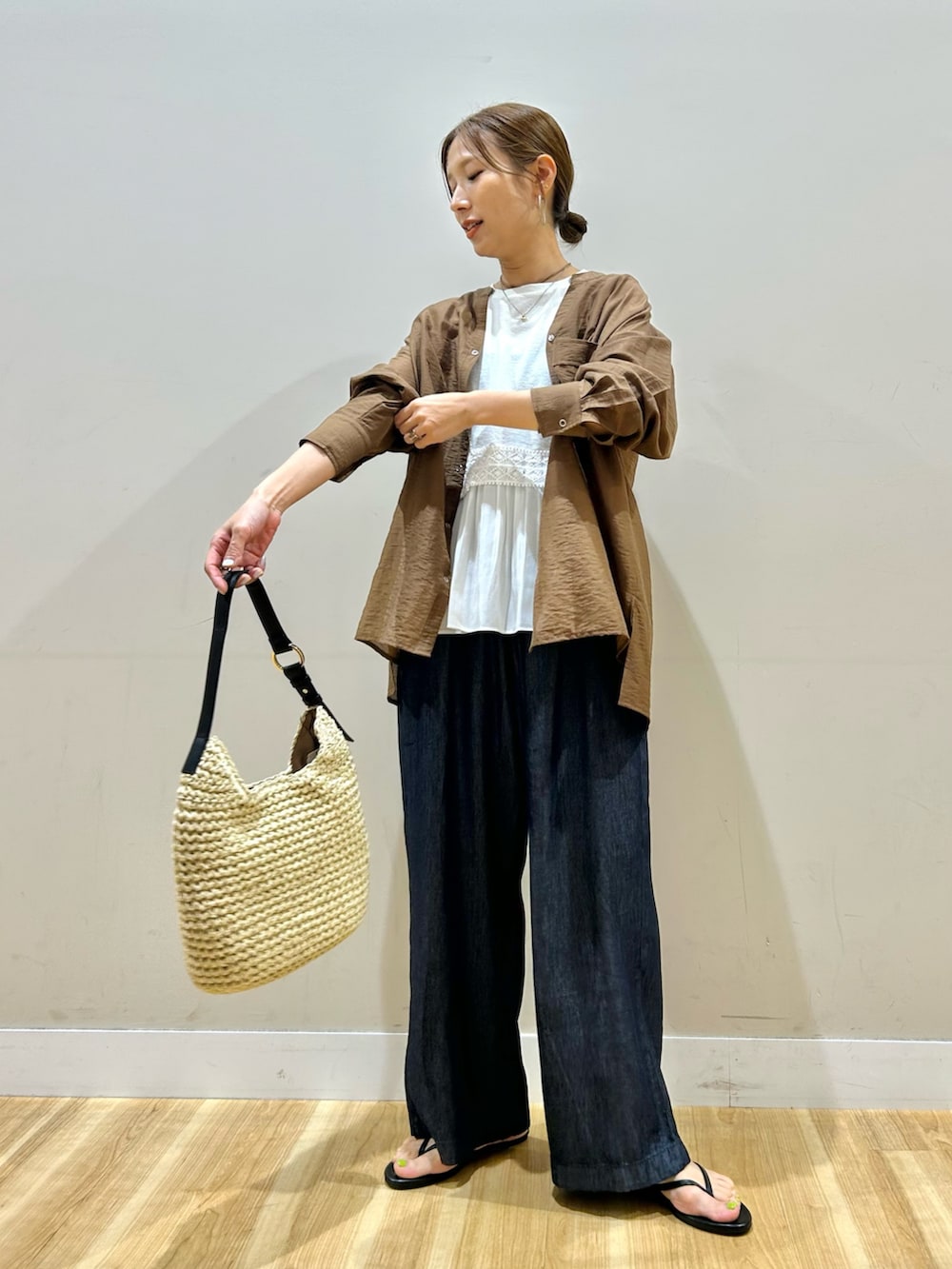 ブラウン系のシャツ/ブラウス、ホワイト系のTシャツ/カットソー、ブルー系のデニムパンツを着用したレディースの夏コーディネートの2枚目の写真
