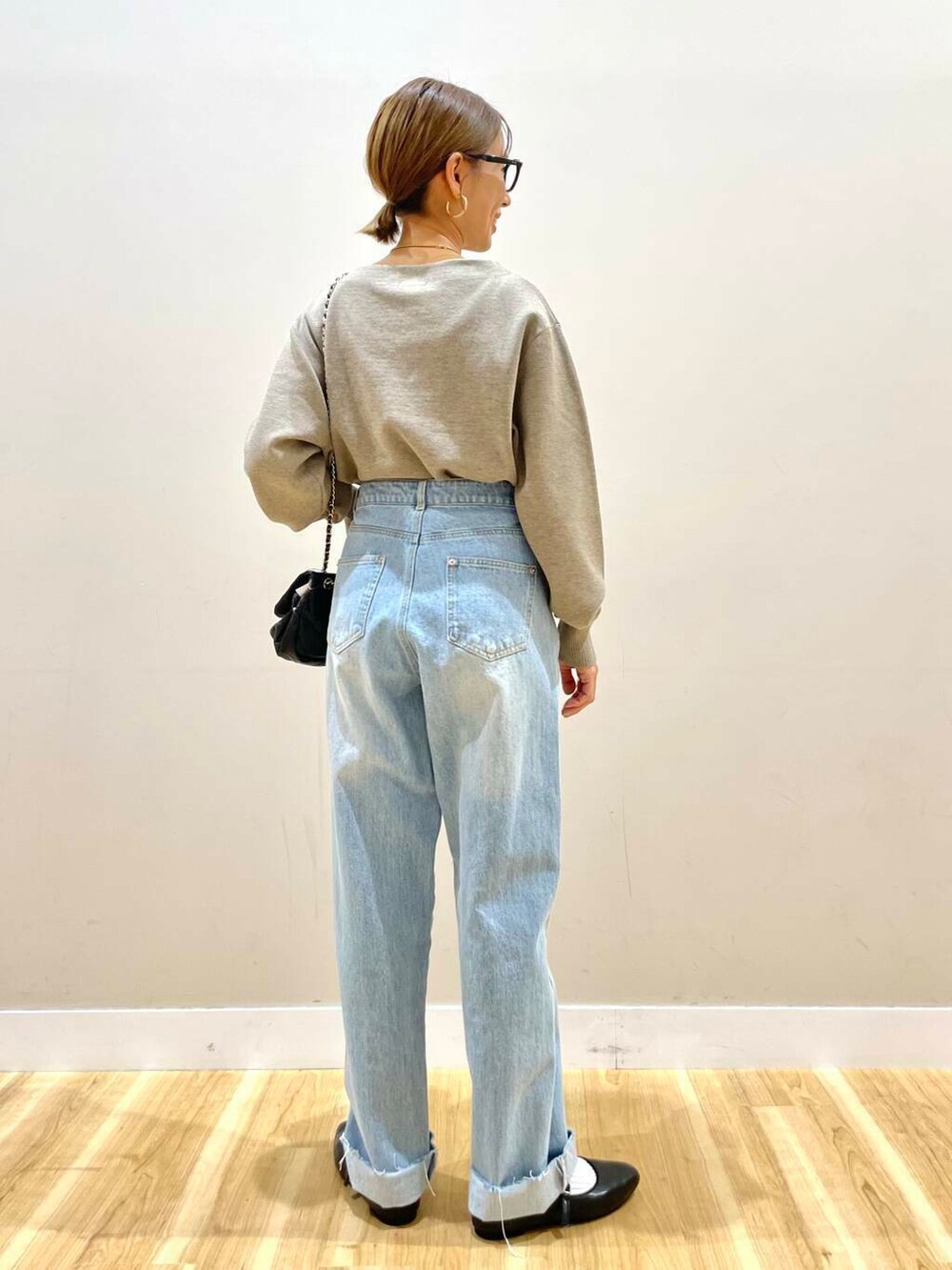 ブラック系のパンプス、ベージュ系のニット/セーター、ブルー系のデニムパンツを着用したレディースの冬コーディネートの9枚目の写真