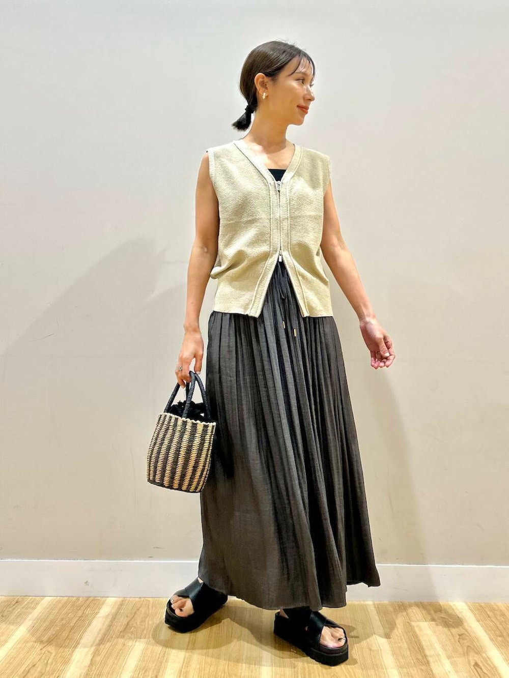 ブラック系のハンドバッグ、グレー系のその他パンツ、ブラック系のサンダルを着用したレディースの夏コーディネートの4枚目の写真