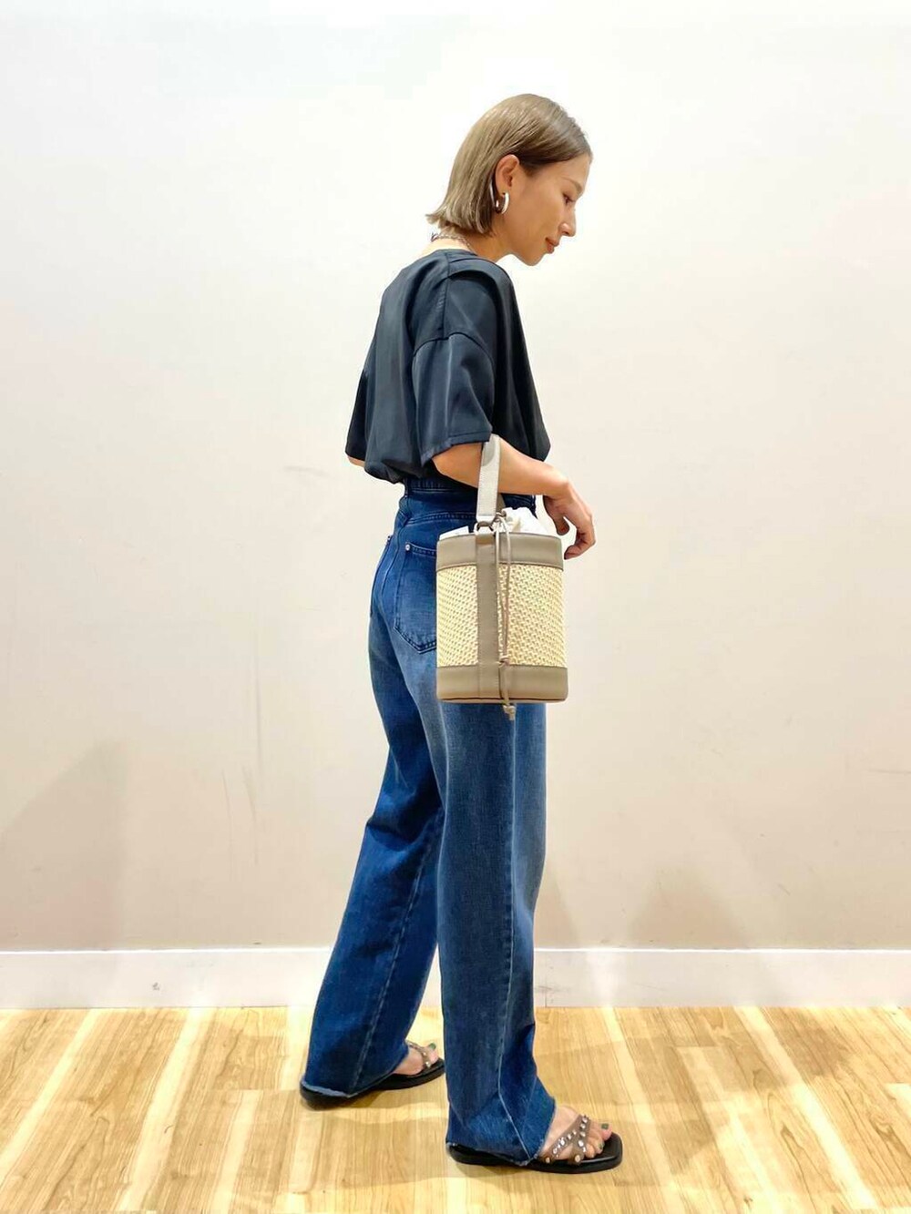 グレー系のショルダーバッグ、ブラック系のサンダル、ブルー系のデニムパンツを着用したレディースの夏コーディネートの3枚目の写真