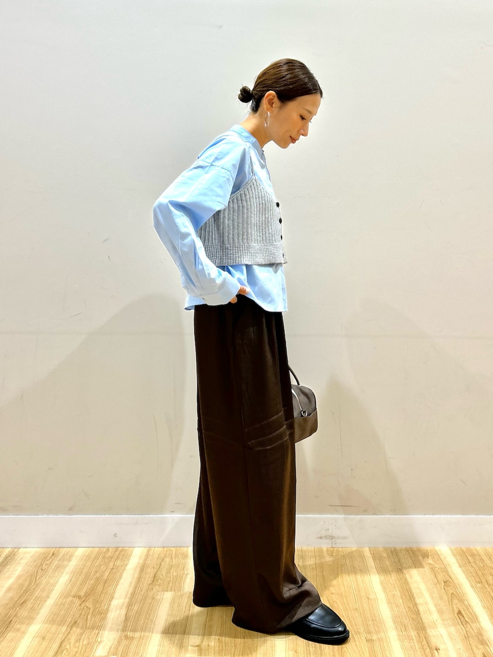 ブルー系のシャツ/ブラウス、ブラウン系のその他パンツ、ブラウン系のボストンバッグを着用したレディースの秋コーディネートの2枚目の写真