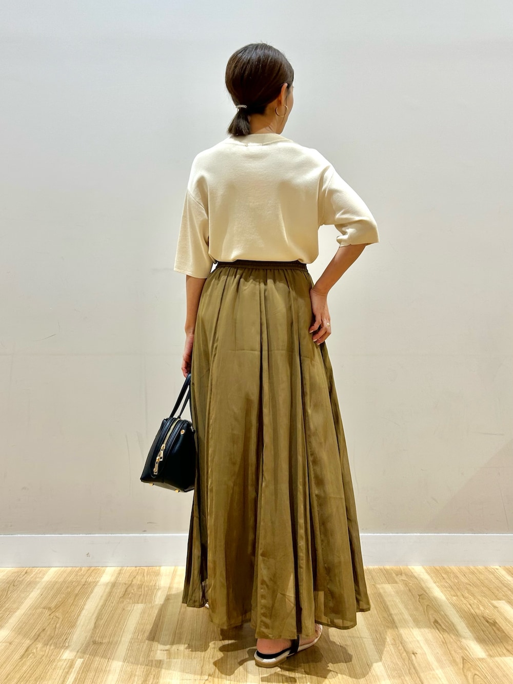 ホワイト系のニット/セーター、ブラウン系のスカートを着用したレディースの夏コーディネートの4枚目の写真