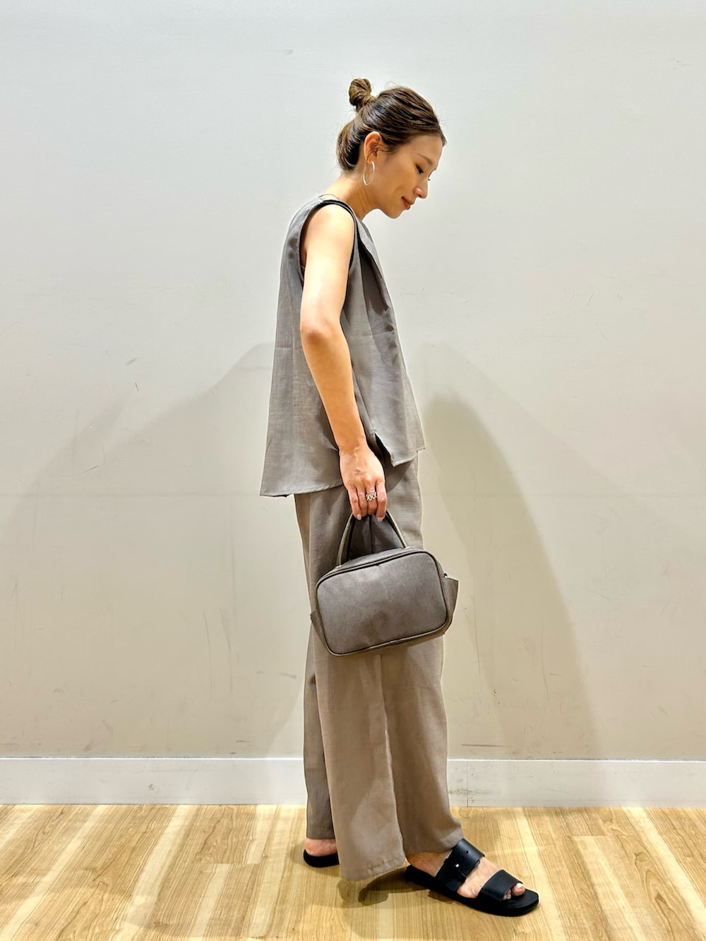 ホワイト系のシャツ/ブラウス、ベージュ系のサロペット/オーバーオール、ブラウン系のボストンバッグを着用したレディースの春コーディネートの6枚目の写真