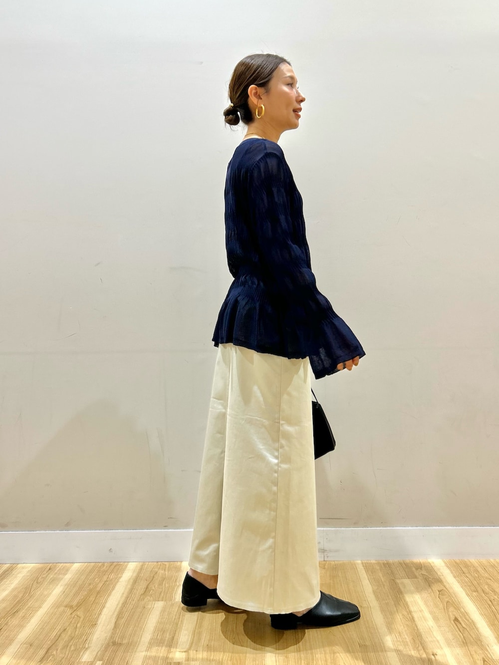 グレー系のパーカー、ブルー系のニット/セーター、ブラック系のスリッポンを着用したレディースの春コーディネートの5枚目の写真