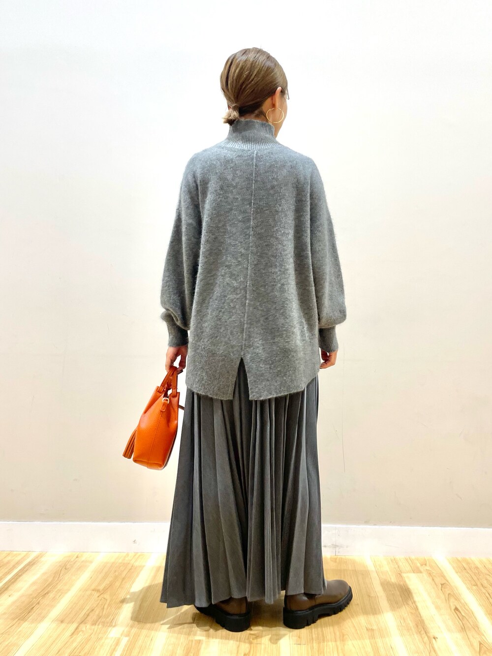 ホワイト系のダウンジャケット/コート、グレー系のニット/セーター、グレー系のスカートを着用したレディースの冬コーディネートの8枚目の写真