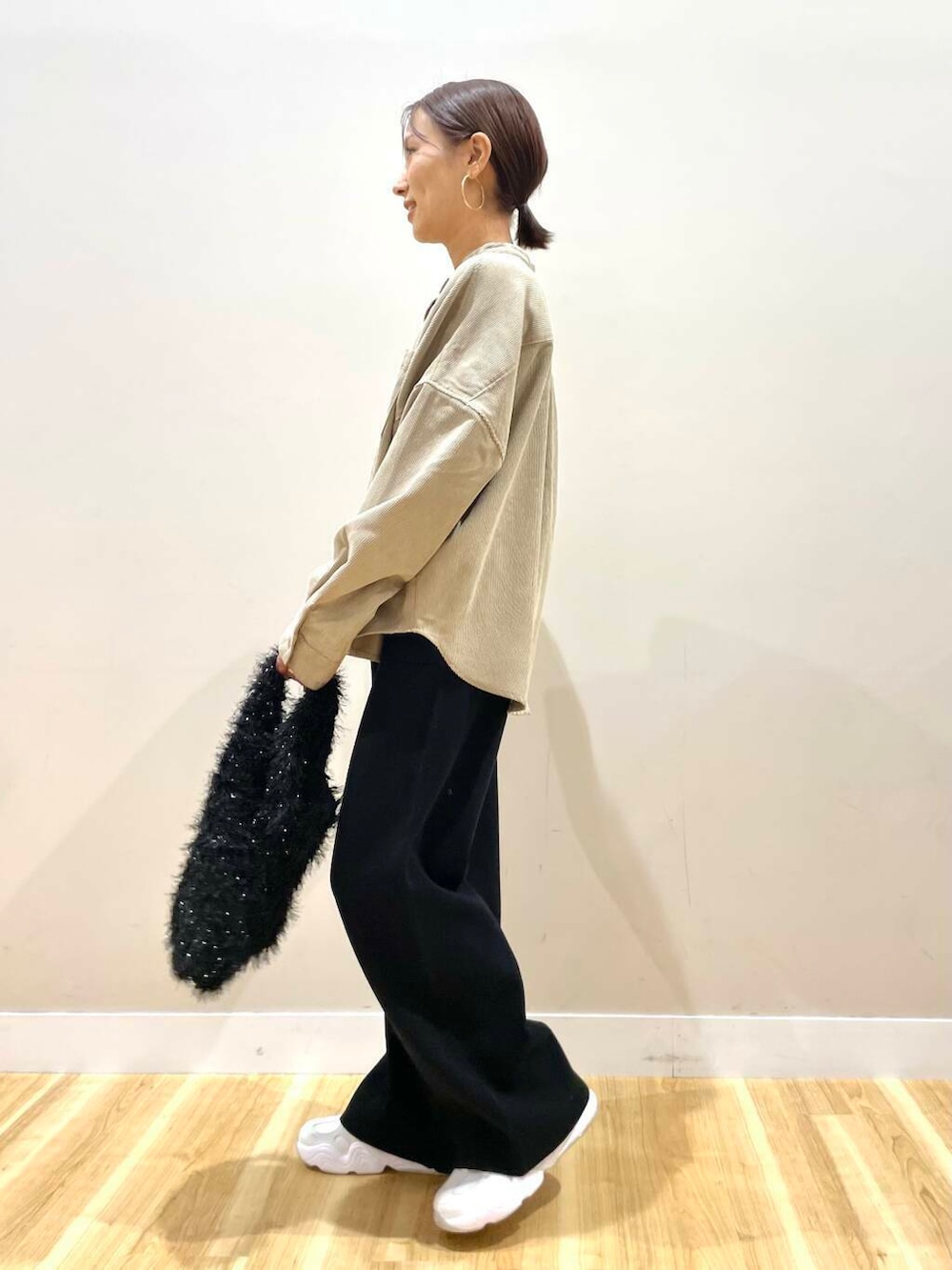 ホワイト系のスニーカー、ベージュ系のTシャツ/カットソー、ブラック系のダウンジャケット/コートを着用したレディースの冬コーディネートの7枚目の写真