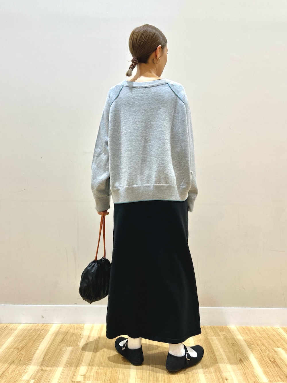 ベージュ系のダウンジャケット/コート、グレー系のニット/セーター、ブラック系のスカートを着用したレディースの秋コーディネートの6枚目の写真