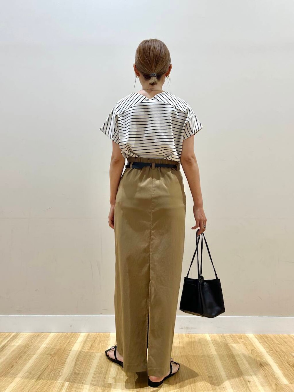 ホワイト系のTシャツ/カットソー、ブラック系のハンドバッグ、イエロー系のスカートを着用したレディースの夏コーディネートの3枚目の写真