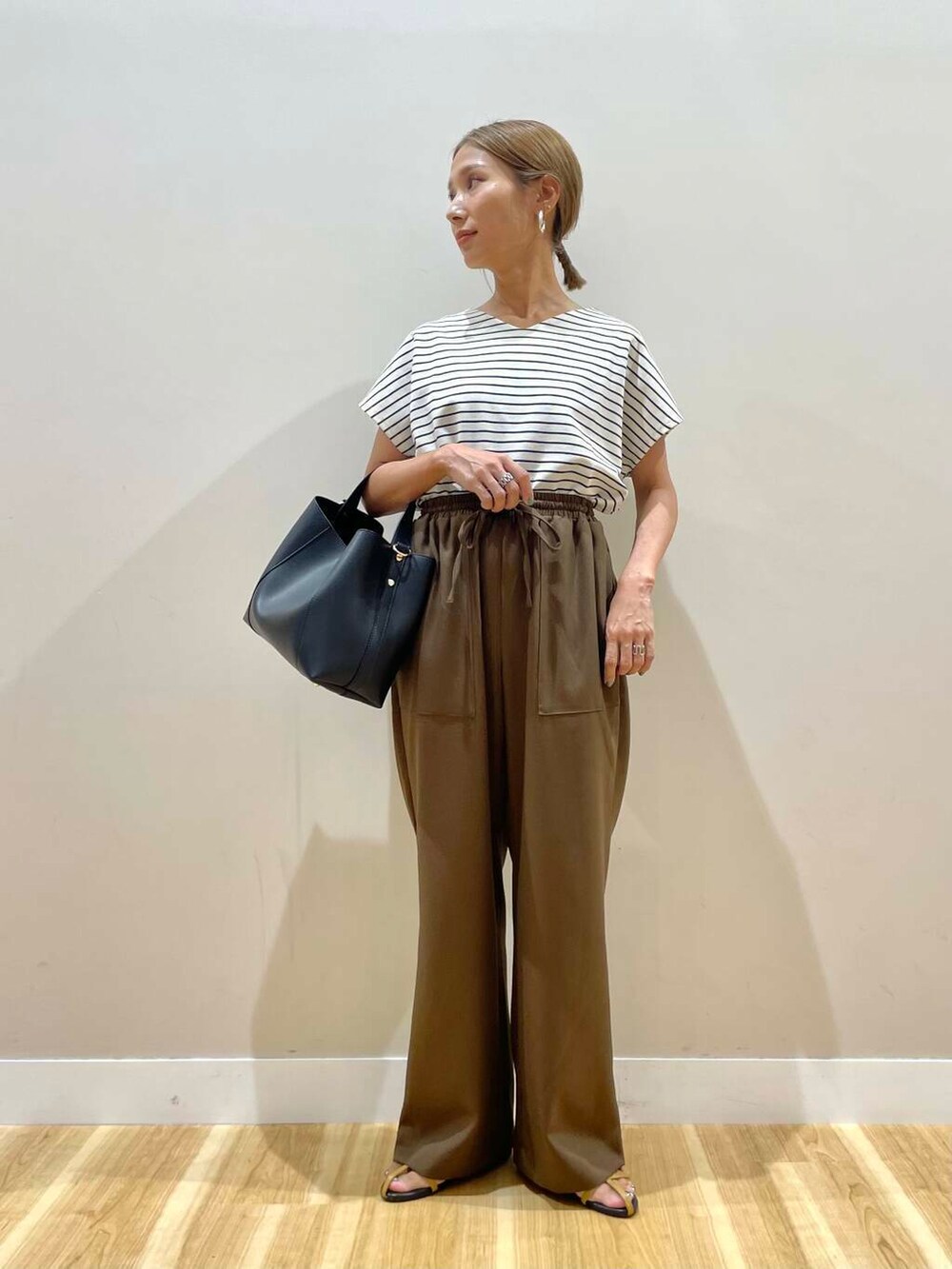 ブラウン系のサンダル、ホワイト系のTシャツ/カットソー、ブラック系のトートバッグを着用したレディースの夏コーディネートの5枚目の写真