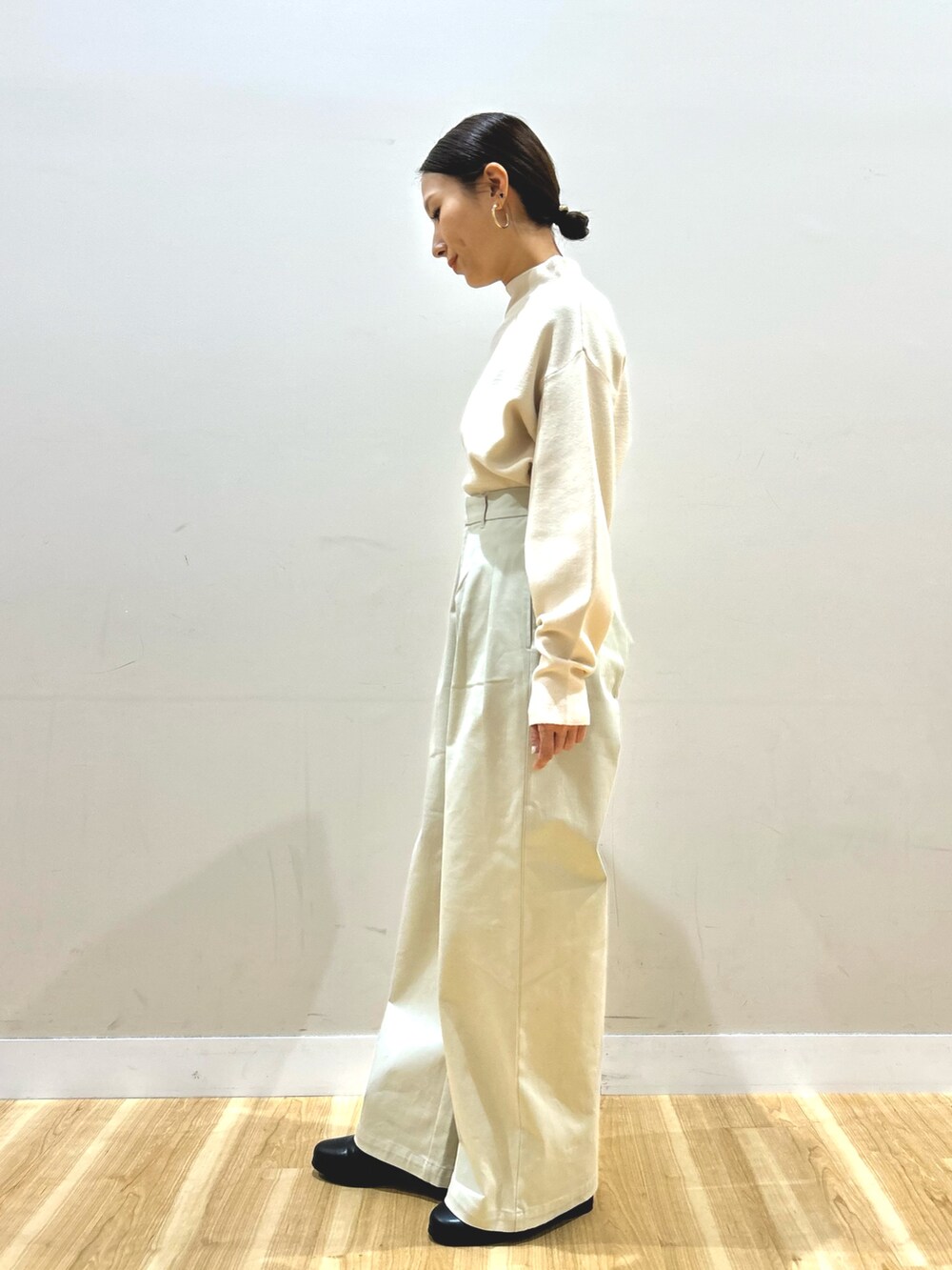 ブルー系のダウンジャケット/コート、ホワイト系のニット/セーター、ベージュ系のその他パンツを着用したレディースの冬コーディネートの5枚目の写真