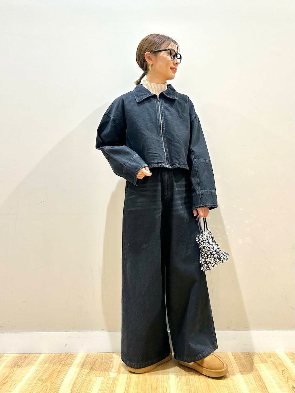 ホワイト系のニット/セーター、シルバー系のショルダーバッグ、ブラック系のデニムパンツを着用したレディースの冬コーディネートの5枚目の写真