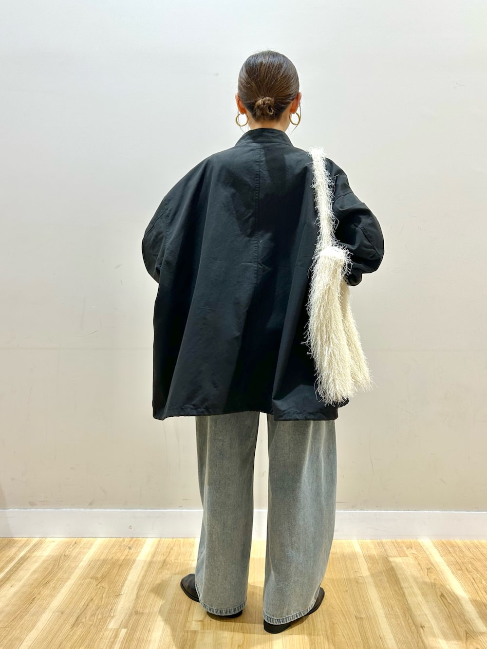 ブラック系のモッズコート、ピンク系のベスト、ピンク系のニット/セーターを着用したレディースの冬コーディネートの3枚目の写真