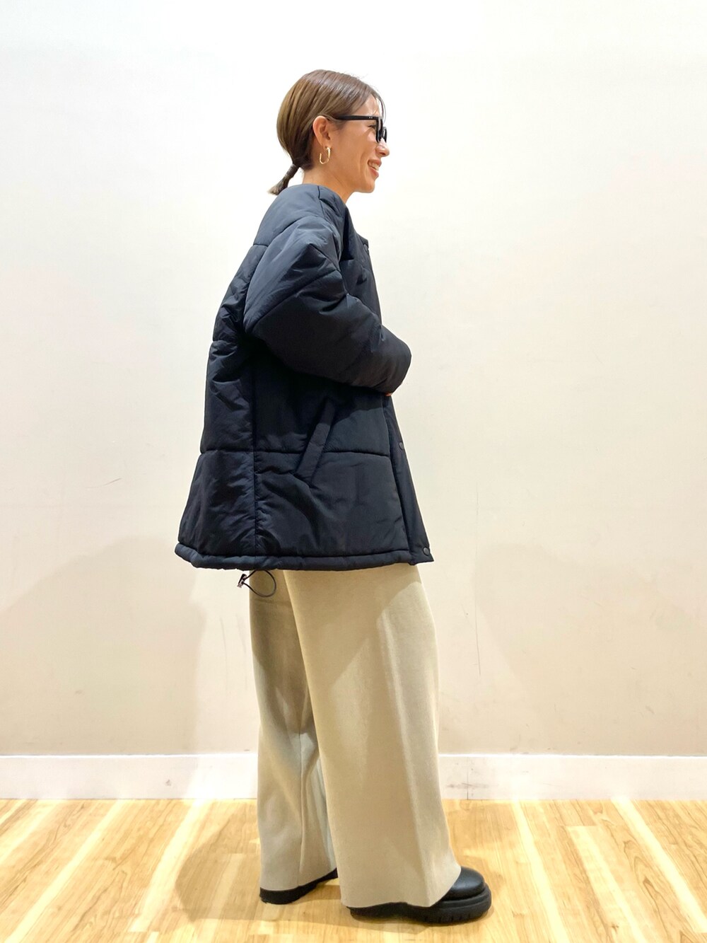 ブラック系のダウンジャケット/コート、ホワイト系のニット/セーター、ベージュ系のその他パンツを着用したレディースの冬コーディネートの3枚目の写真