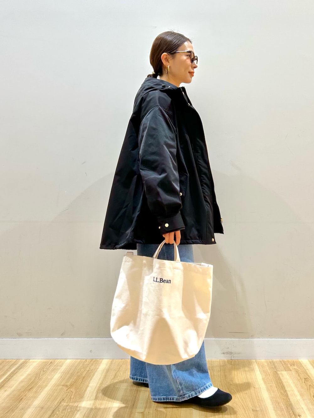 ブルー系のデニムパンツ、ベージュ系のショルダーバッグ、ピンク系のニット/セーターを着用したレディースの冬コーディネートの2枚目の写真