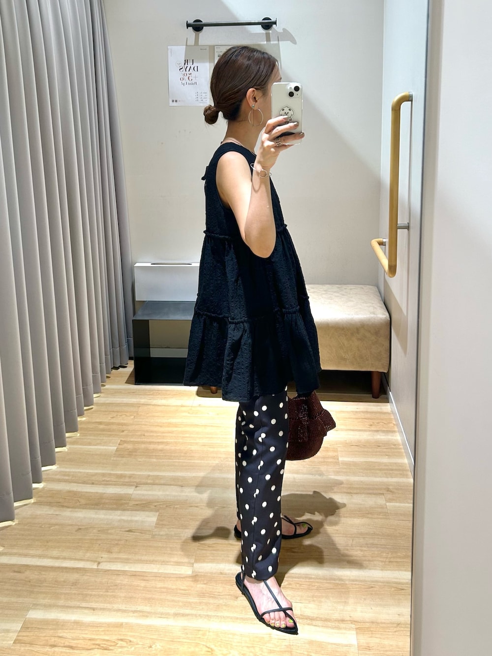ブラック系のチュニック、ブラック系のその他パンツ、ブラウン系のショルダーバッグを着用したレディースの春コーディネートの2枚目の写真