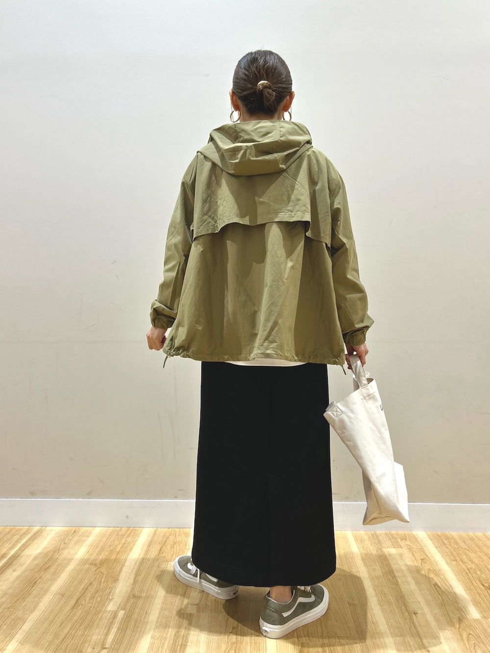 ベージュ系のマウンテンパーカー、ベージュ系のニット/セーター、ブラック系のスカートを着用したレディースの春コーディネートの3枚目の写真