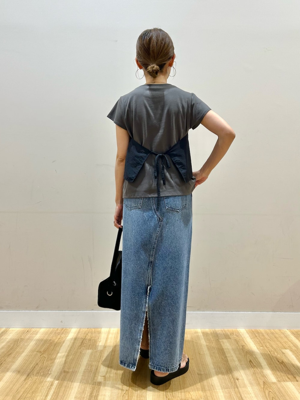 ブラック系のTシャツ/カットソー、ブルー系のスカート、ブラック系のトートバッグを着用したレディースの夏コーディネートの3枚目の写真