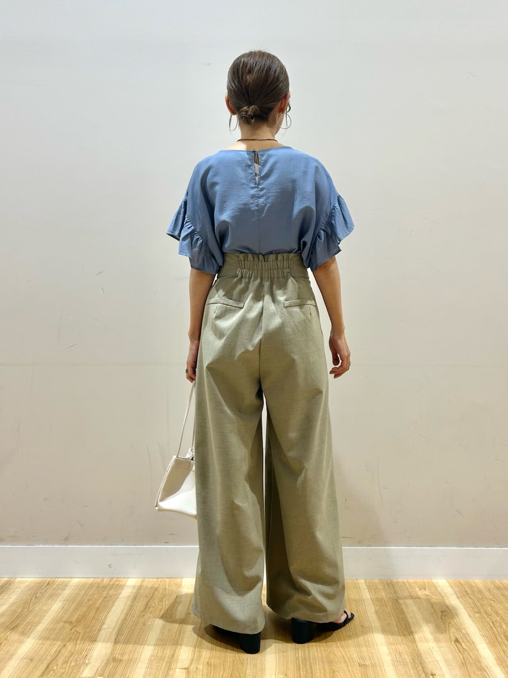 ブルー系のシャツ/ブラウス、ベージュ系のその他パンツ、ホワイト系のハンドバッグを着用したレディースの夏コーディネートの2枚目の写真