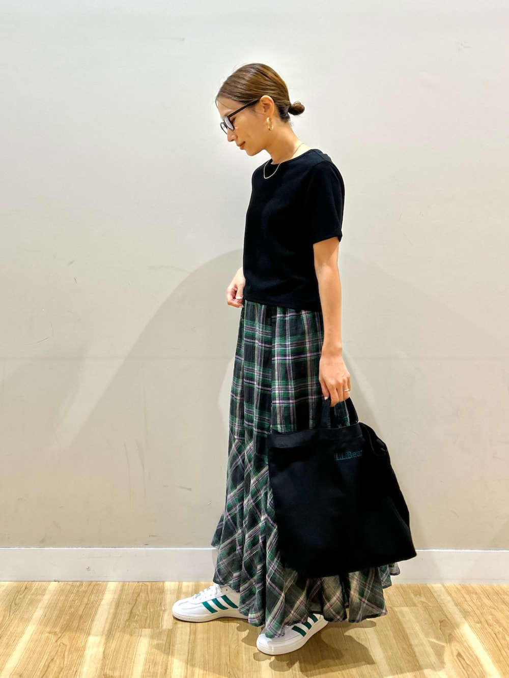 ブラック系のTシャツ/カットソー、グリーン系のスカート、ホワイト系のスニーカーを着用したレディースの夏コーディネートの4枚目の写真
