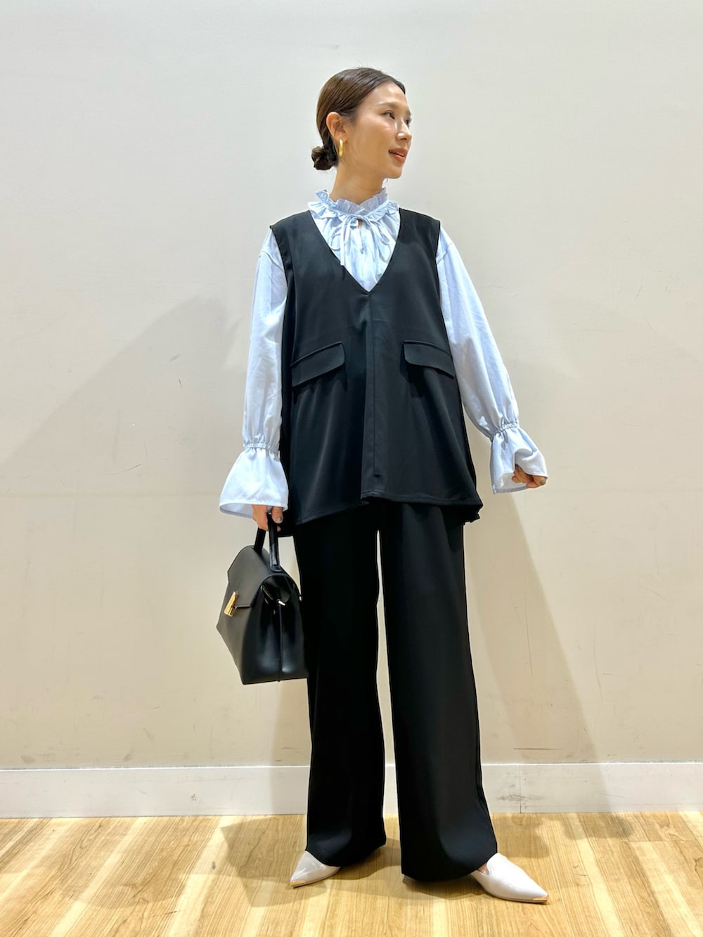 ブルー系のシャツ/ブラウス、ブラック系のセットアップ、ブラック系のハンドバッグを着用したレディースの冬コーディネートの4枚目の写真