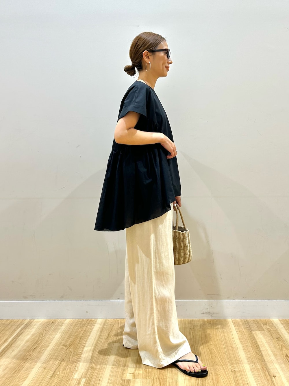 ブラック系のシャツ/ブラウス、ベージュ系のその他パンツ、グレー系のハンドバッグを着用したレディースの夏コーディネートの2枚目の写真