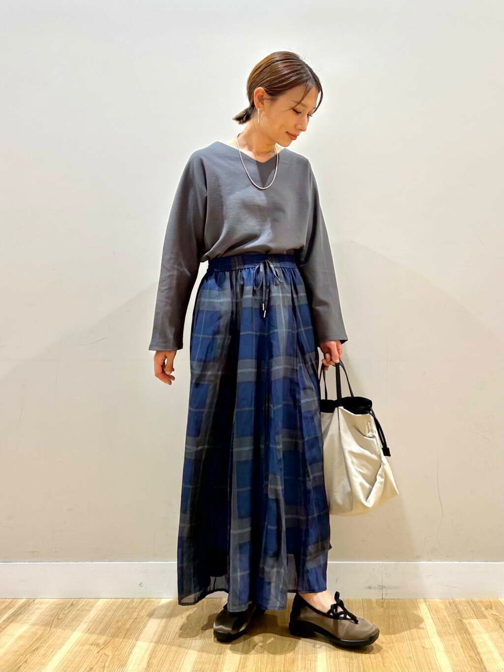 ホワイト系のショルダーバッグ、グレー系のTシャツ/カットソー、グリーン系のスニーカーを着用したレディースの春コーディネートの2枚目の写真