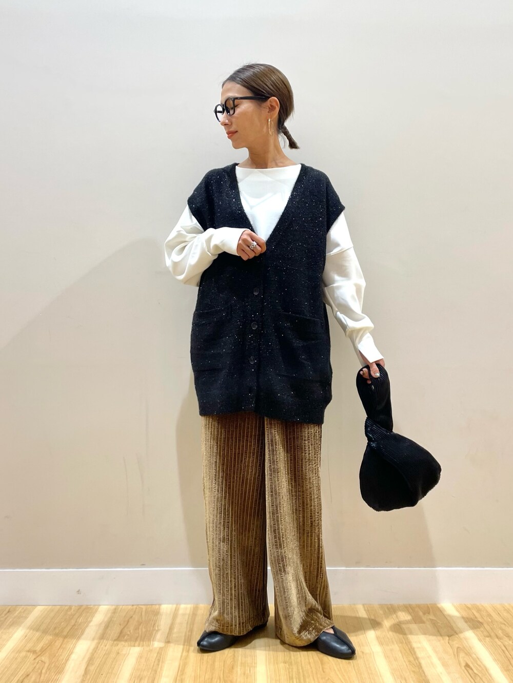 ブラック系のベスト、ホワイト系のTシャツ/カットソー、ブラウン系のその他パンツを着用したレディースの秋コーディネートの6枚目の写真