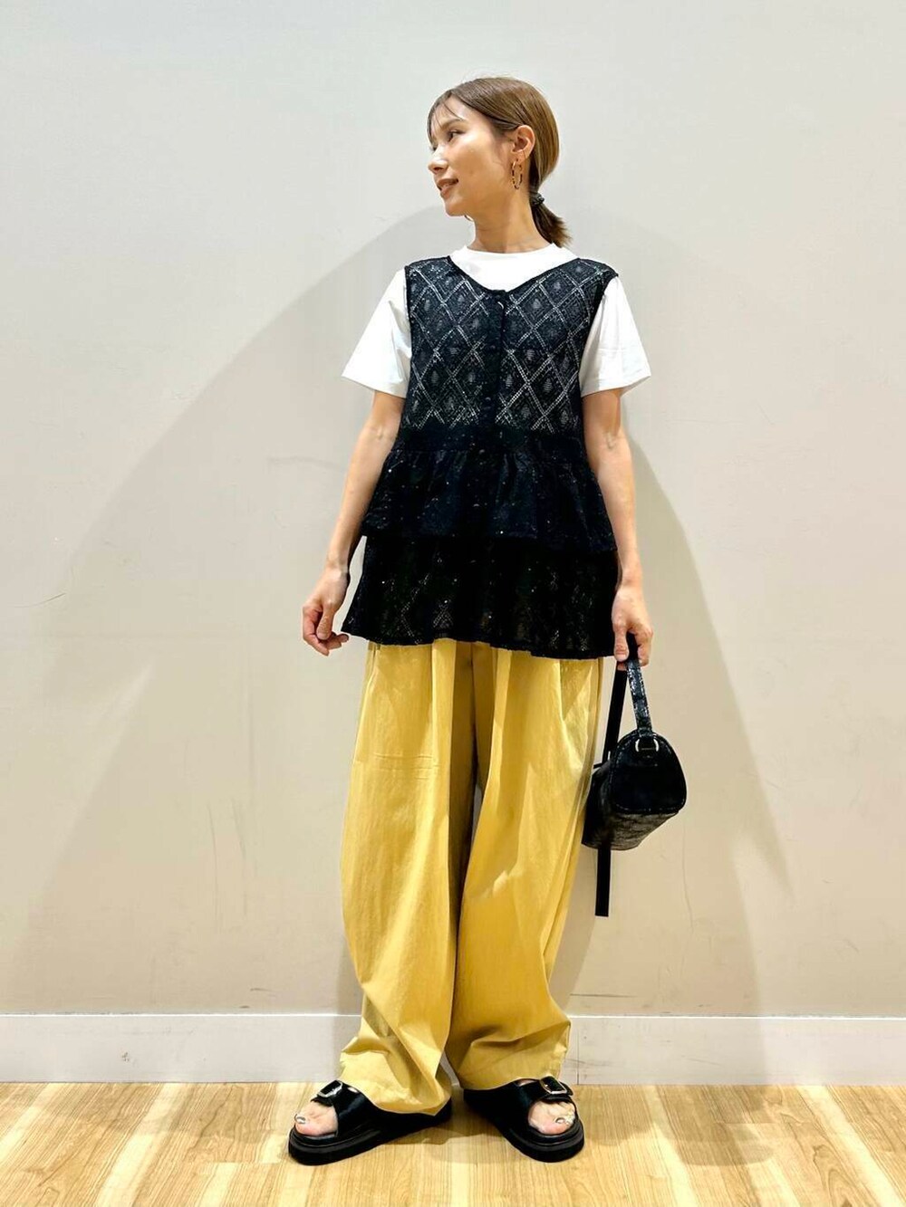 ブラック系のハンドバッグ、ベージュ系のその他パンツ、ホワイト系のTシャツ/カットソーを着用したレディースの夏コーディネートの4枚目の写真