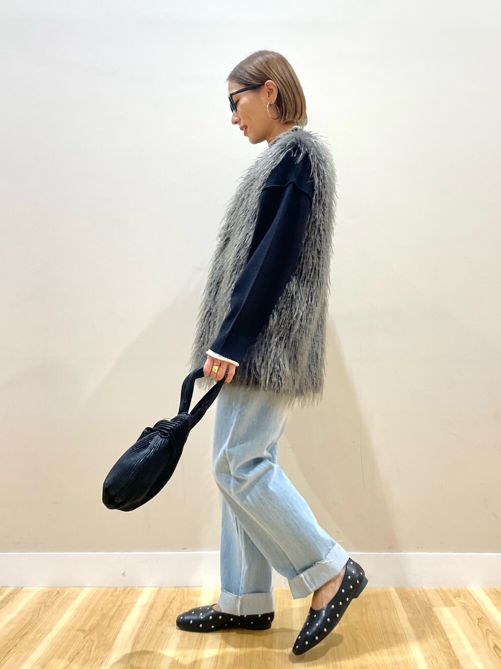 グレー系のその他アウター、ブラック系のニット/セーター、ブルー系のデニムパンツを着用したレディースの秋コーディネートの5枚目の写真