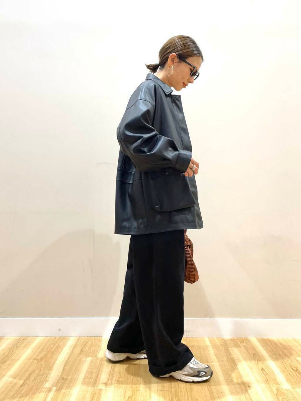 ホワイト系のニット/セーター、ブラウン系のハンドバッグ、ブラック系のその他アウターを着用したレディースの秋コーディネートの3枚目の写真