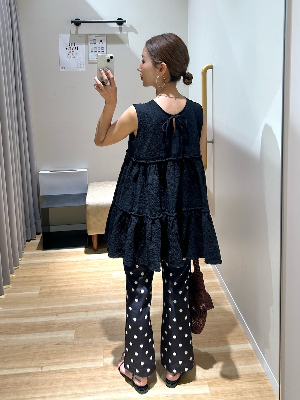 ブラック系のチュニック、ブラック系のその他パンツ、ブラウン系のショルダーバッグを着用したレディースの春コーディネートの3枚目の写真