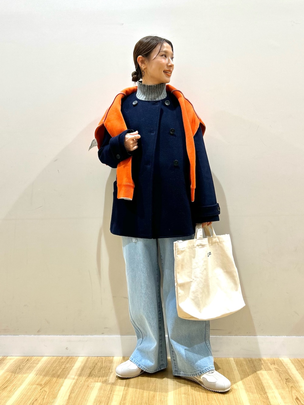 ブルー系のピーコート、グレー系のニット/セーター、オレンジ系のニット/セーターを着用したレディースの冬コーディネートの7枚目の写真