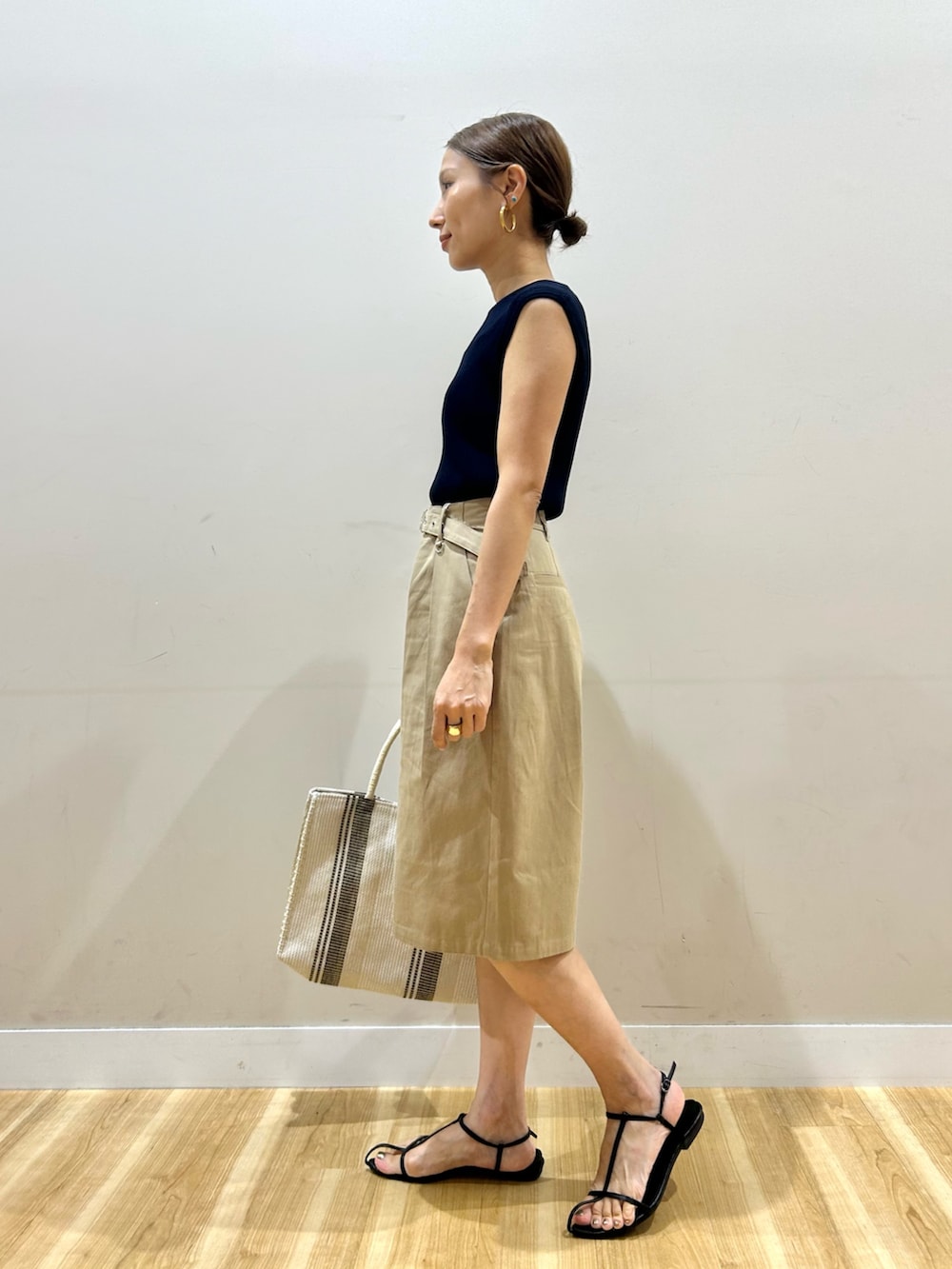ブルー系のニット/セーター、ベージュ系のその他パンツ、ホワイト系のトートバッグを着用したレディースの夏コーディネートの2枚目の写真