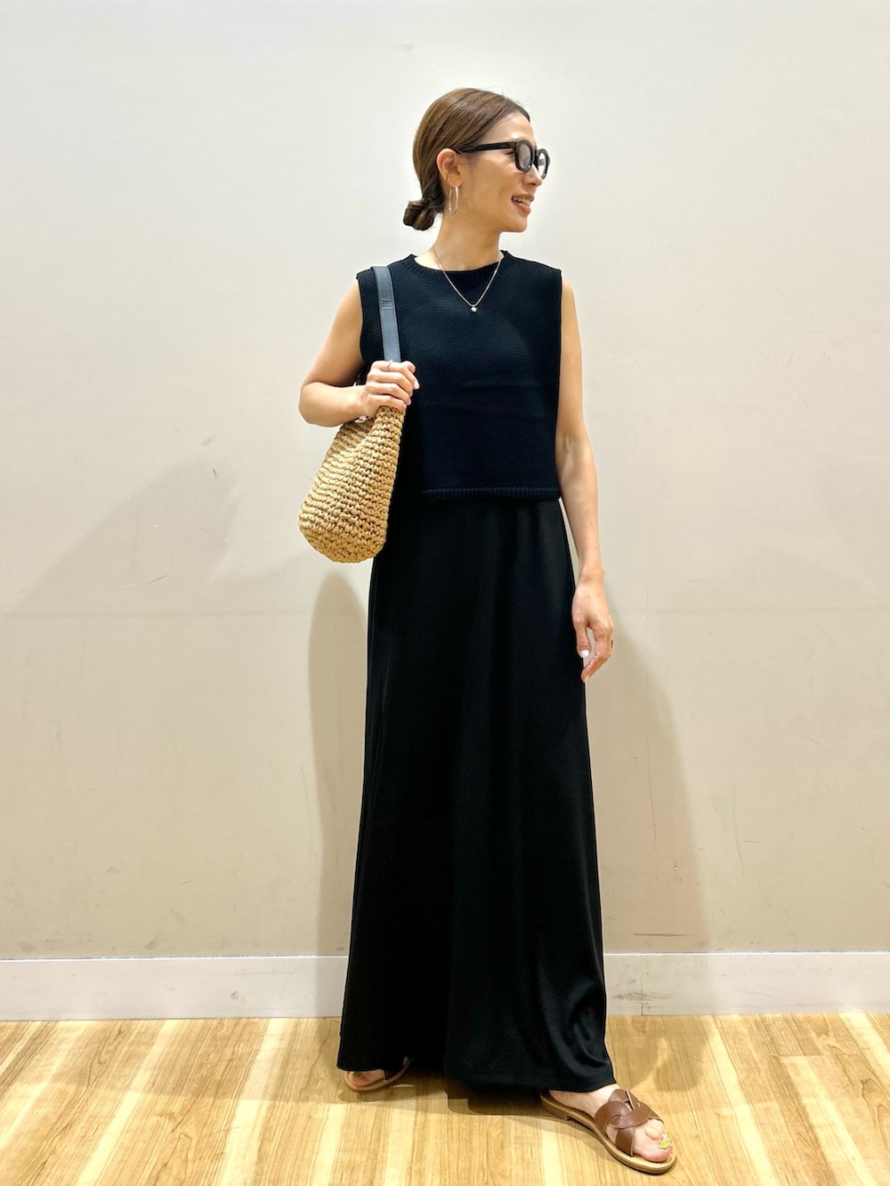 ブラック系のワンピース、ブラウン系のサンダル、ブラウン系のメガネを着用したレディースの夏コーディネートの4枚目の写真