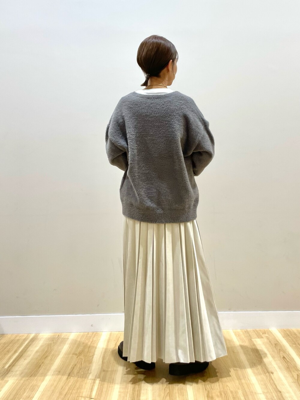 グレー系のニット/セーター、グレー系のダウンジャケット/コート、ホワイト系のTシャツ/カットソーを着用したレディースの冬コーディネートの7枚目の写真