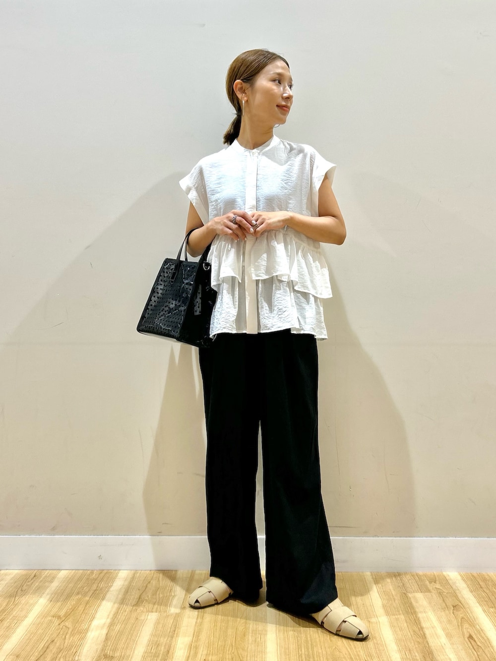 ホワイト系のシャツ/ブラウス、ブラック系のその他パンツ、ブラック系のハンドバッグを着用したレディースの夏コーディネートの5枚目の写真