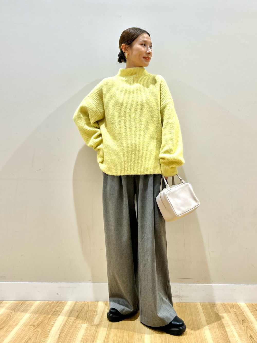 グレー系のノーカラージャケット、イエロー系のニット/セーター、グレー系のその他パンツを着用したレディースの冬コーディネートの2枚目の写真