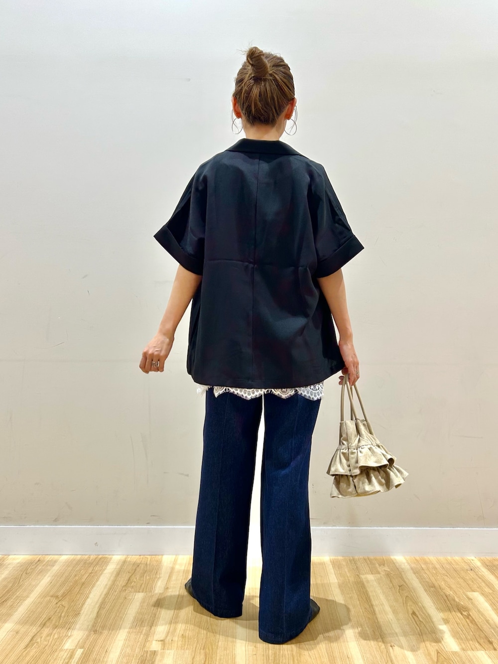 ブラック系のその他アウター、ベージュ系のTシャツ/カットソー、ブルー系のデニムパンツを着用したレディースの春コーディネートの4枚目の写真