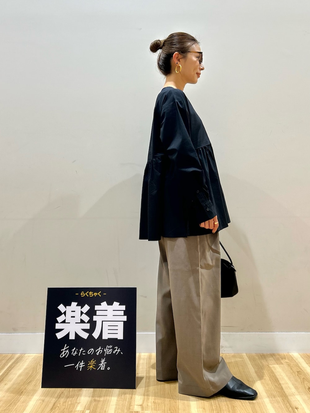 ホワイト系のブルゾン、ブラック系のシャツ/ブラウス、ブラック系のトートバッグを着用したレディースの春コーディネートの6枚目の写真