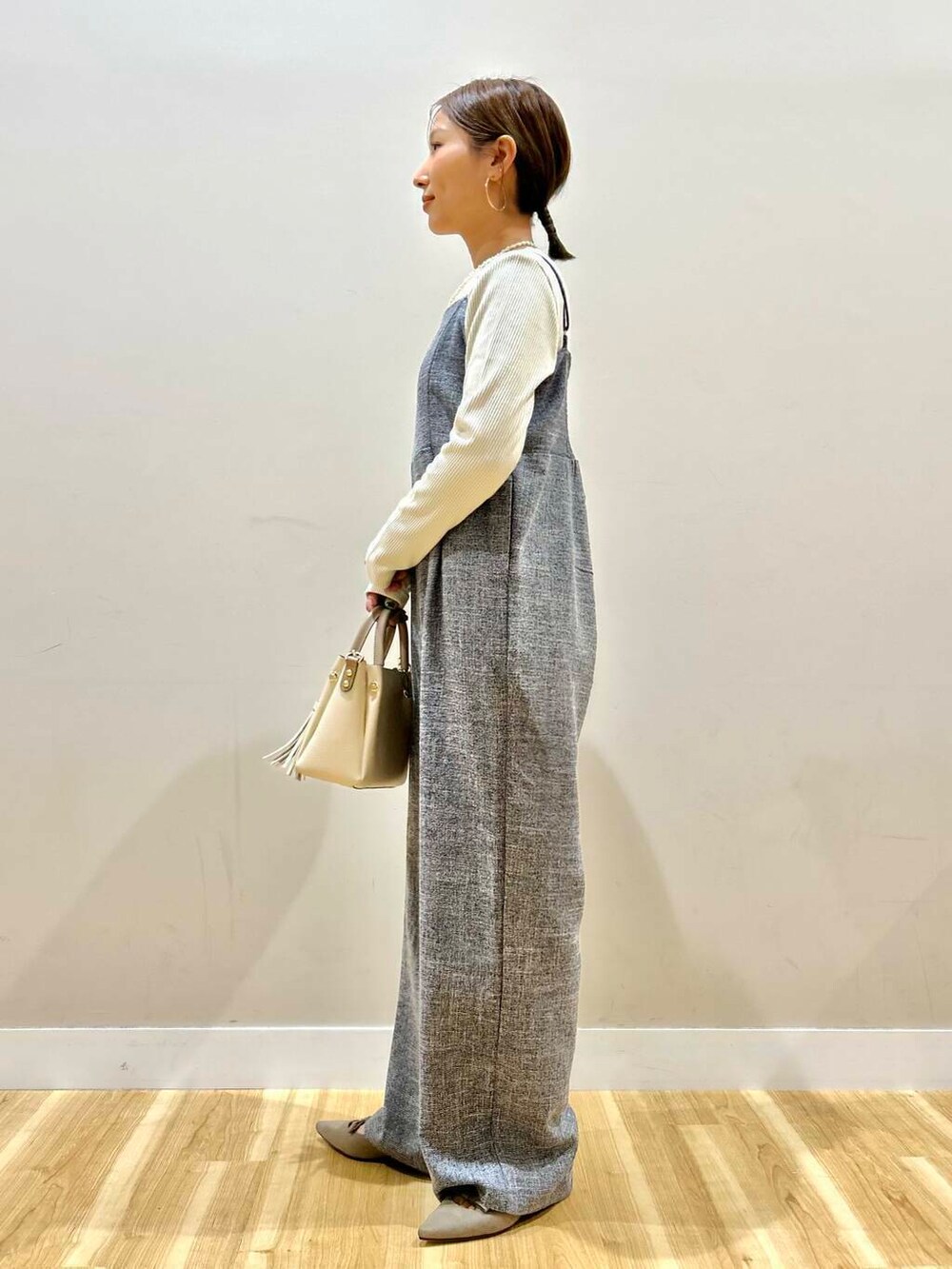 ホワイト系のトートバッグ、グレー系のパンプス、ブラック系のノーカラージャケットを着用したレディースの冬コーディネートの6枚目の写真