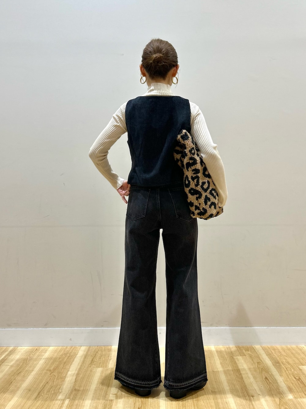 ホワイト系のニット/セーター、ブルー系のダウンベスト、ブラック系のデニムパンツを着用したレディースの秋コーディネートの3枚目の写真