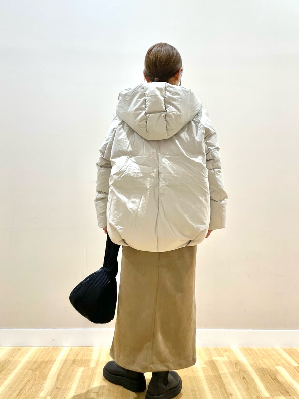 ホワイト系のダウンジャケット/コート、グレー系のニット/セーター、ブラウン系のスカートを着用したレディースの冬コーディネートの3枚目の写真