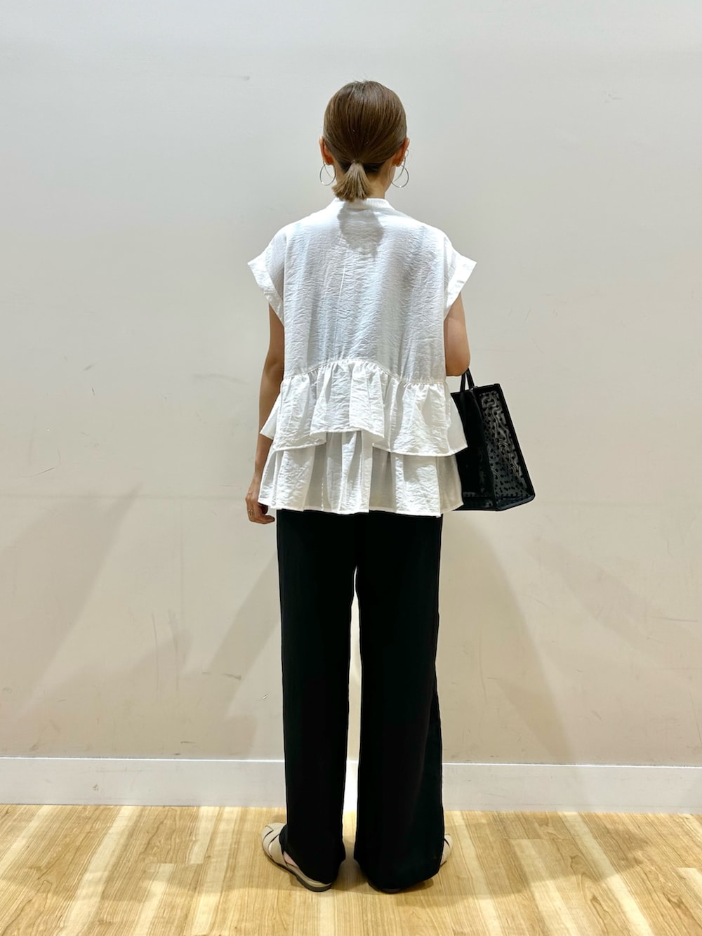 ホワイト系のシャツ/ブラウス、ブラック系のその他パンツ、ブラック系のハンドバッグを着用したレディースの夏コーディネートの3枚目の写真