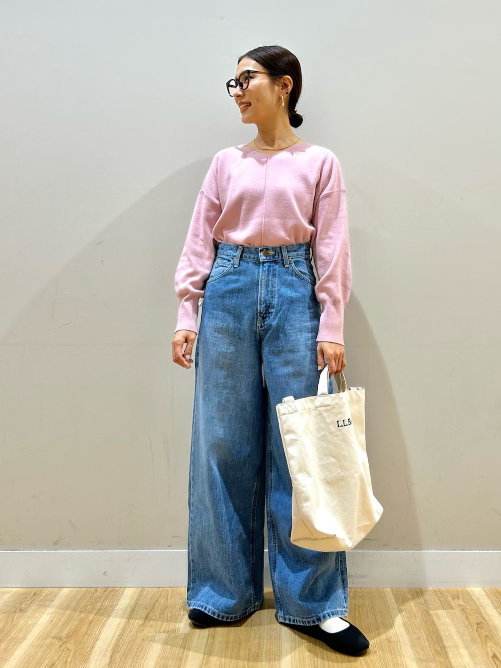 ブルー系のデニムパンツ、ベージュ系のショルダーバッグ、ピンク系のニット/セーターを着用したレディースの冬コーディネートの5枚目の写真