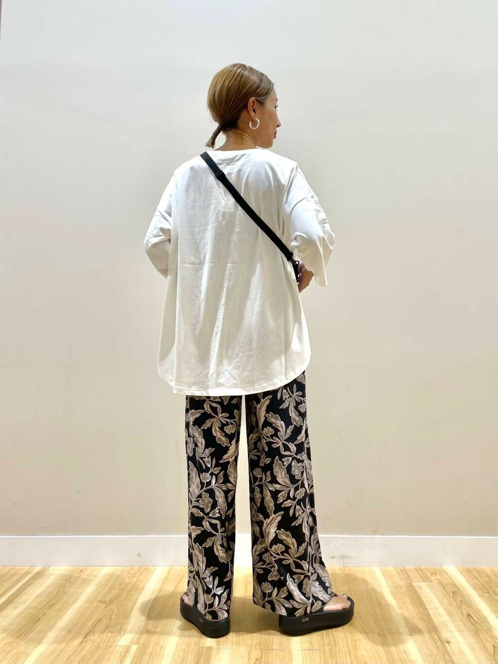 ブラック系のショルダーバッグ、ブラック系のその他パンツ、ホワイト系のTシャツ/カットソーを着用したレディースの夏コーディネートの3枚目の写真