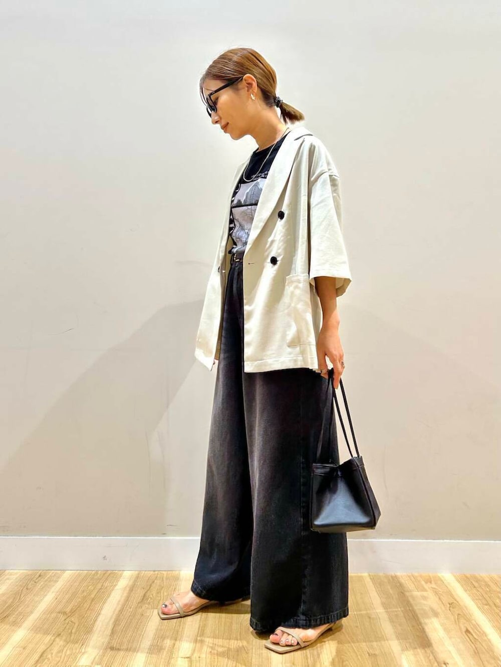 グレー系のサンダル、ブラック系のデニムパンツ、ベージュ系のその他アウターを着用したレディースの春コーディネートの3枚目の写真