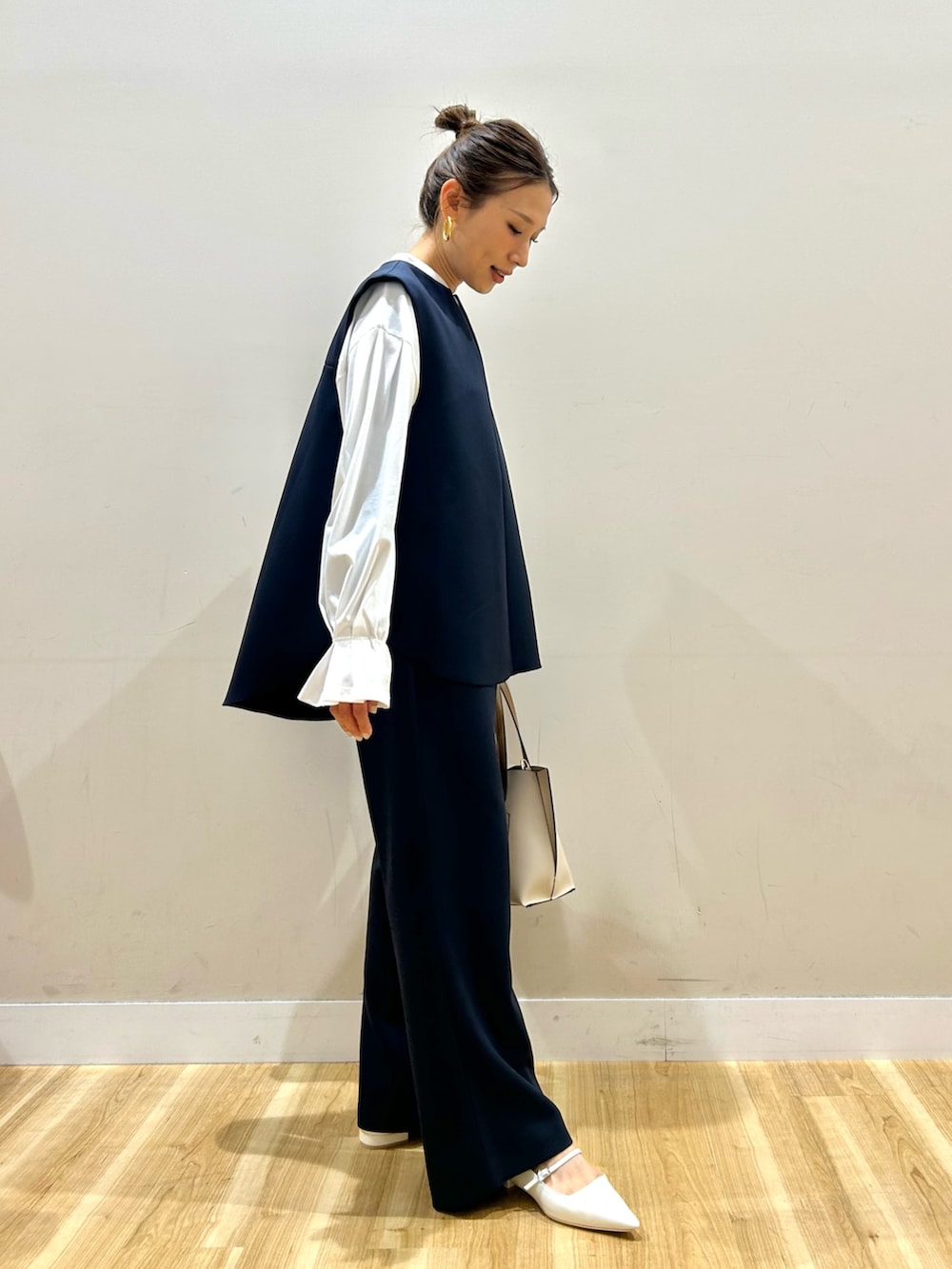 ブルー系のセットアップ、ホワイト系のシャツ/ブラウス、ベージュ系のトートバッグを着用したレディースの春コーディネートの2枚目の写真