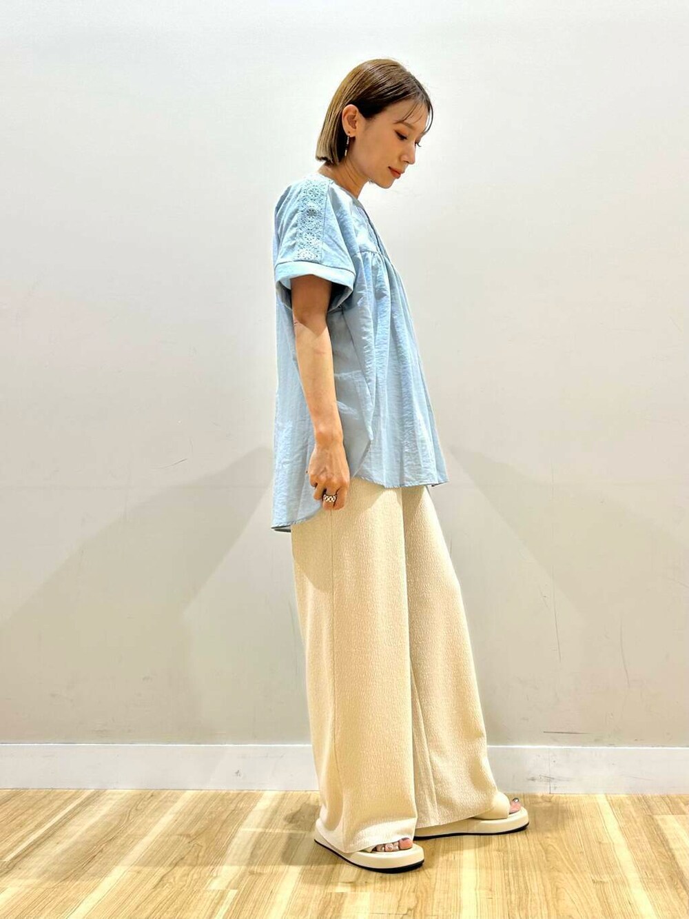 ホワイト系のサンダル、ブルー系のシャツ/ブラウス、ホワイト系のその他パンツを着用したレディースの夏コーディネートの3枚目の写真